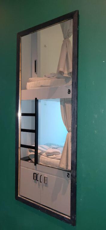 a mirror in a room with two bunk beds at Wink at Mosque Street in Singapore