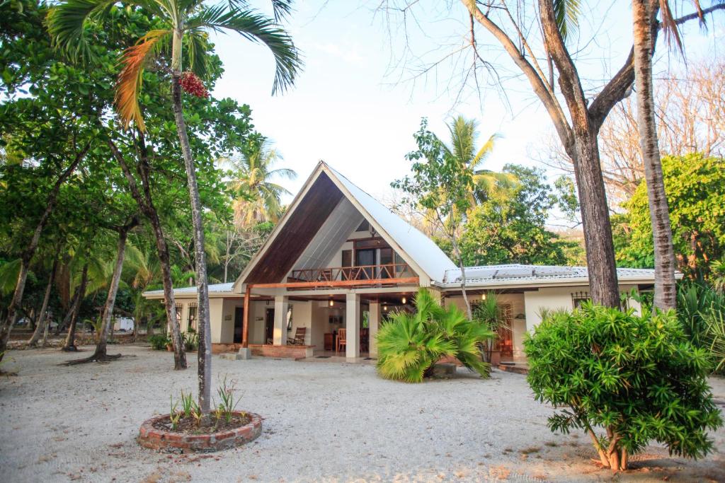 a house with palm trees in front of it at Casa Cecilia Beach Front in Santa Teresa Beach
