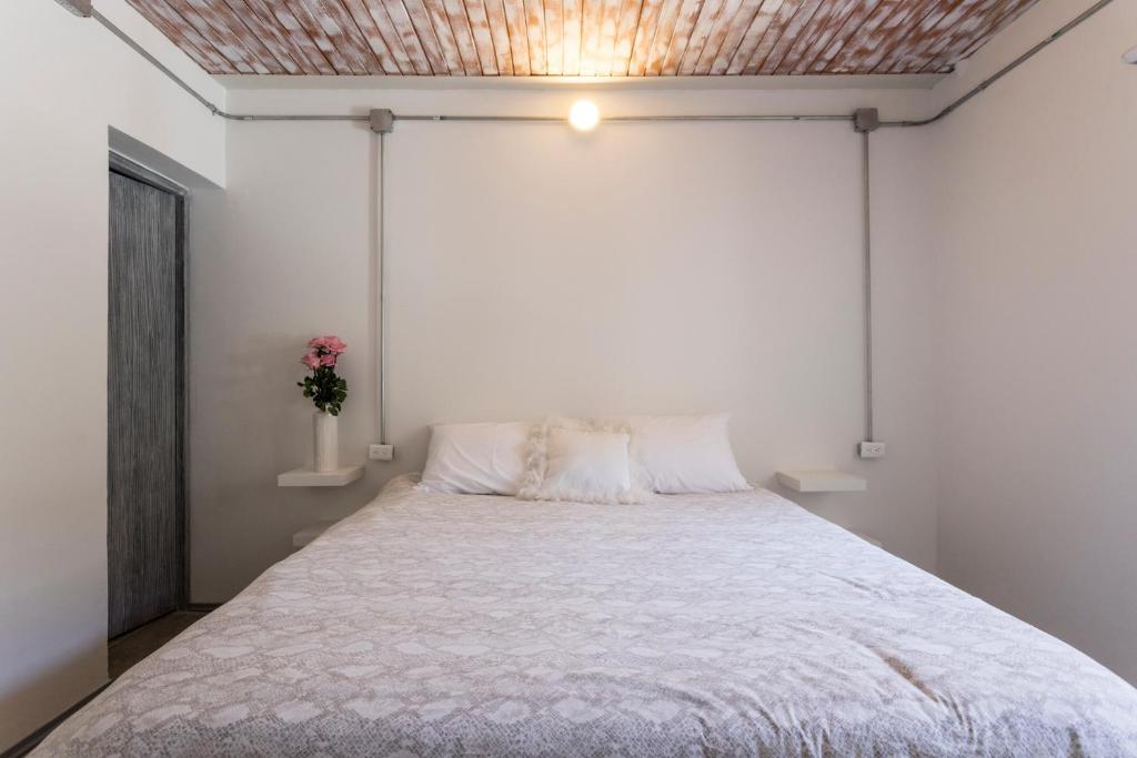 una camera da letto con un letto grande con soffitto di Gastón Coliving a Medellín