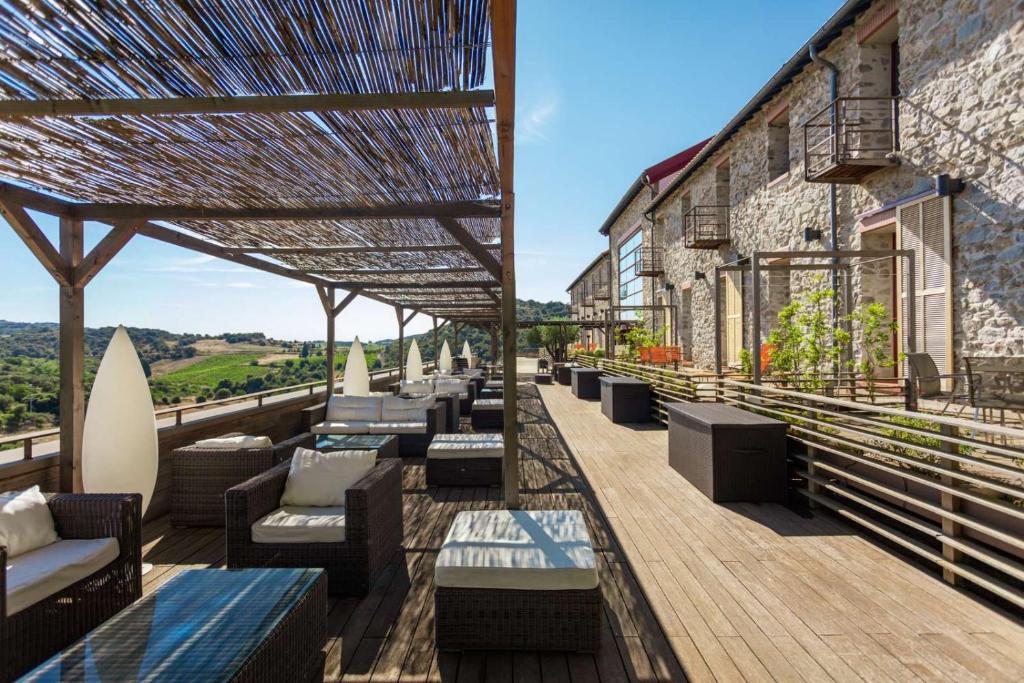 un patio con sofás y sillas en un edificio en Domaine Riberach - Restaurant étoilé - Spa - Piscine naturelle - Vignoble bio, en Bélesta