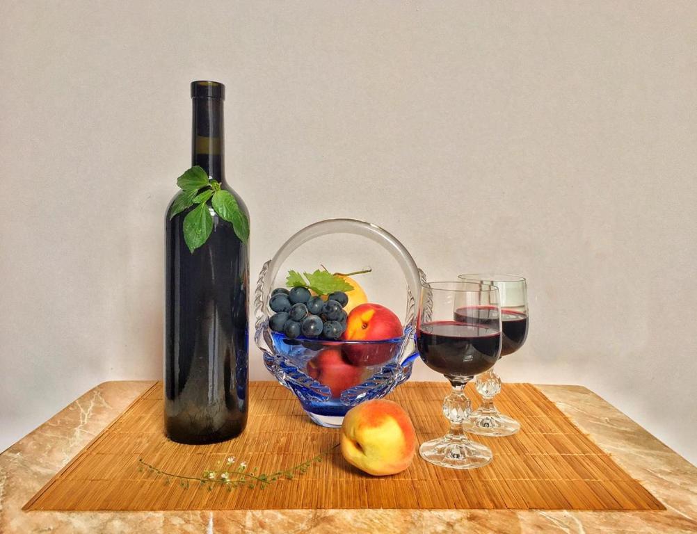 een fles wijn en een fruitschaal op een tafel bij Vercxli 24 in Tbilisi City