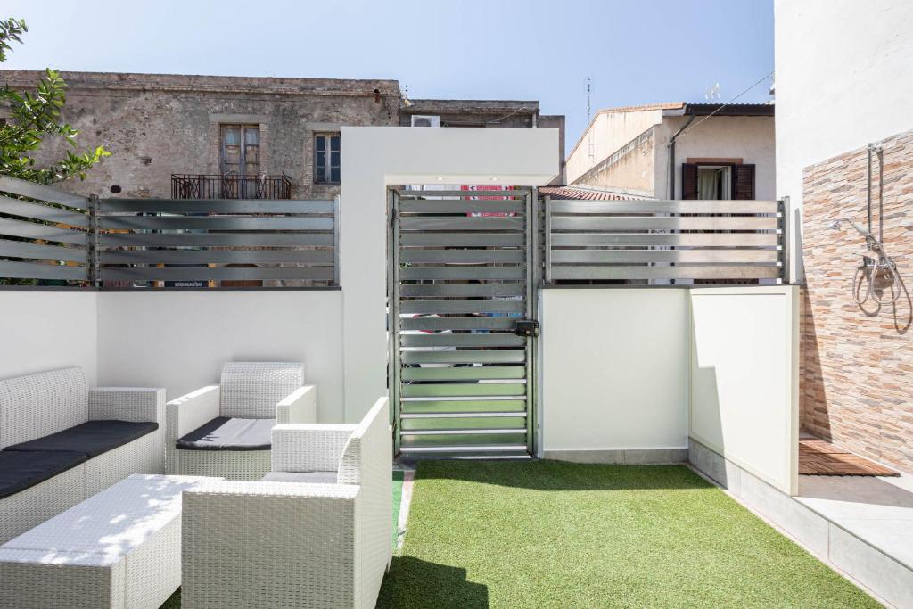 an outdoor patio with a fence and grass at Sea Elegance in Oliveri