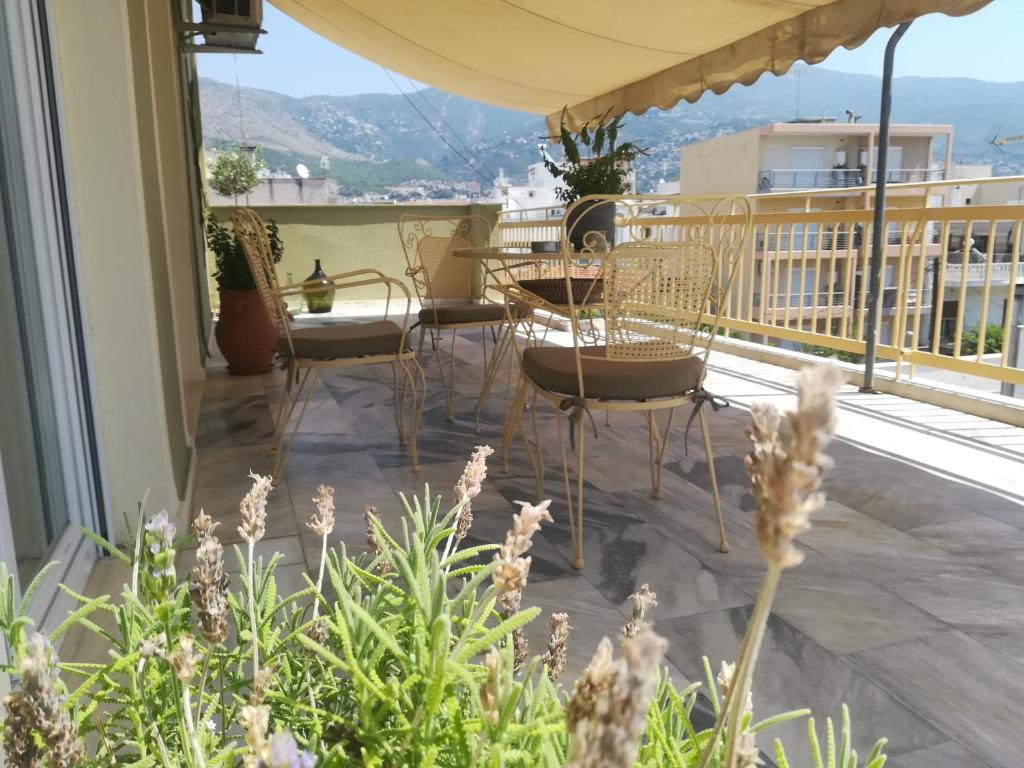 patio z krzesłami i stołami na balkonie w obiekcie Areti' s Home w mieście Wolos