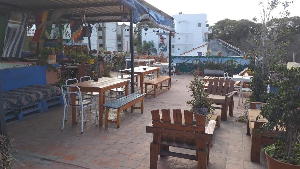 a patio with wooden tables and chairs in a restaurant at La Covacha Youth Hostel in Salta