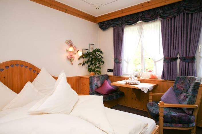 sypialnia z łóżkiem, stołem i krzesłami w obiekcie Hotel Restaurant Rengser Mühle w mieście Bergneustadt