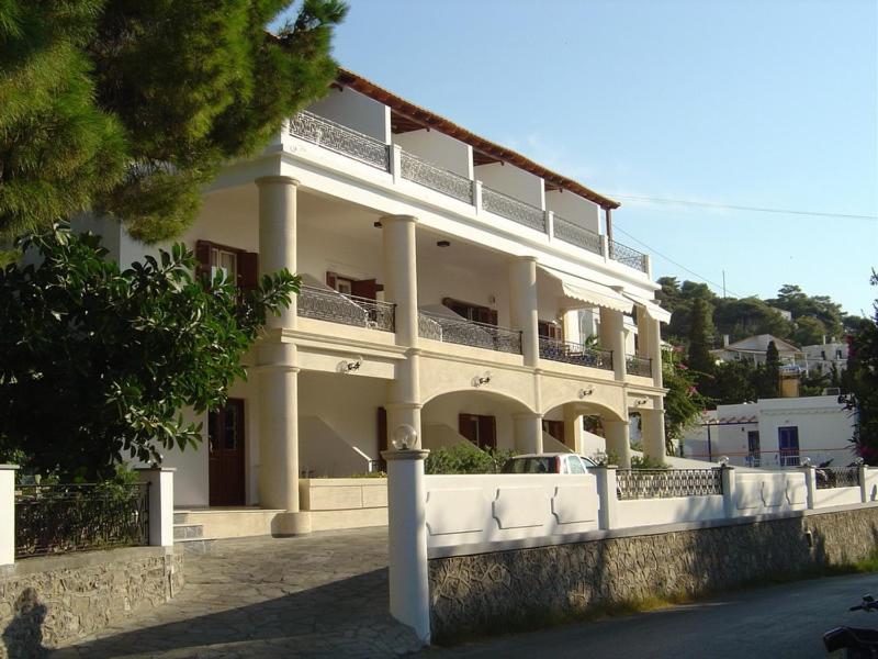 ein großes weißes Gebäude mit Balkon darüber in der Unterkunft Oasis Hotel in Masouri
