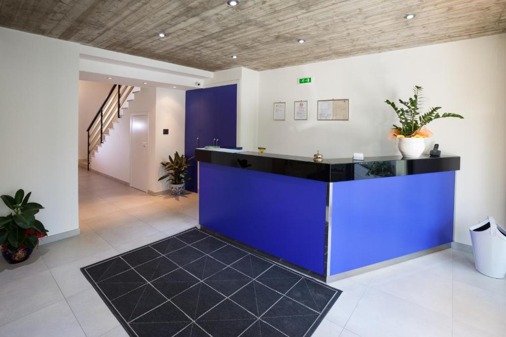 un hall de bureau avec un comptoir bleu et des escaliers dans l'établissement Hotel Garden, à Giulianova