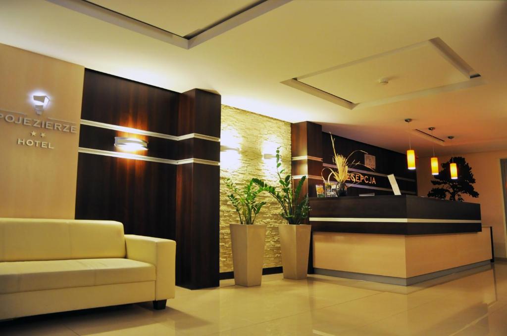 a lobby of a hotel with a couch and a counter at Hotel Pojezierze in Szczecinek