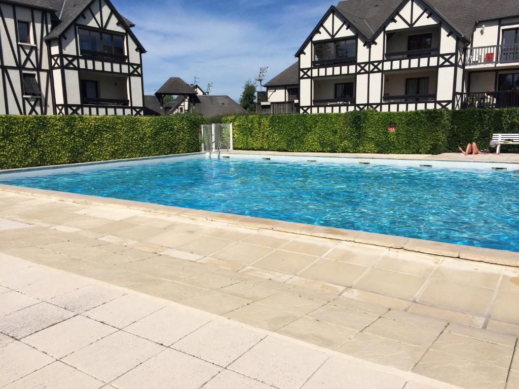 a swimming pool in front of a house at Cottage à Cabourg in Cabourg