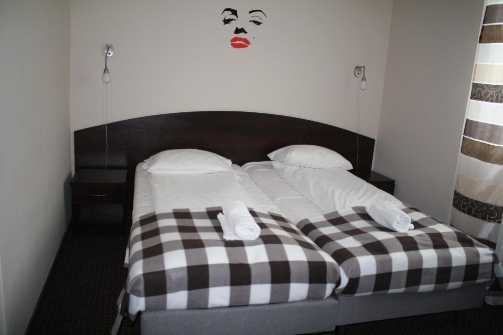 łóżko z 2 poduszkami i maską na ścianie w obiekcie Zajazd u Sosny w mieście Torzym