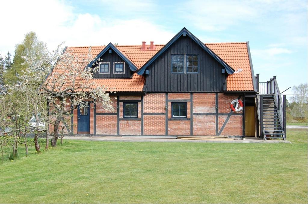 a large brick house with a black roof at Roliga semestrar i Åhus! in Åhus