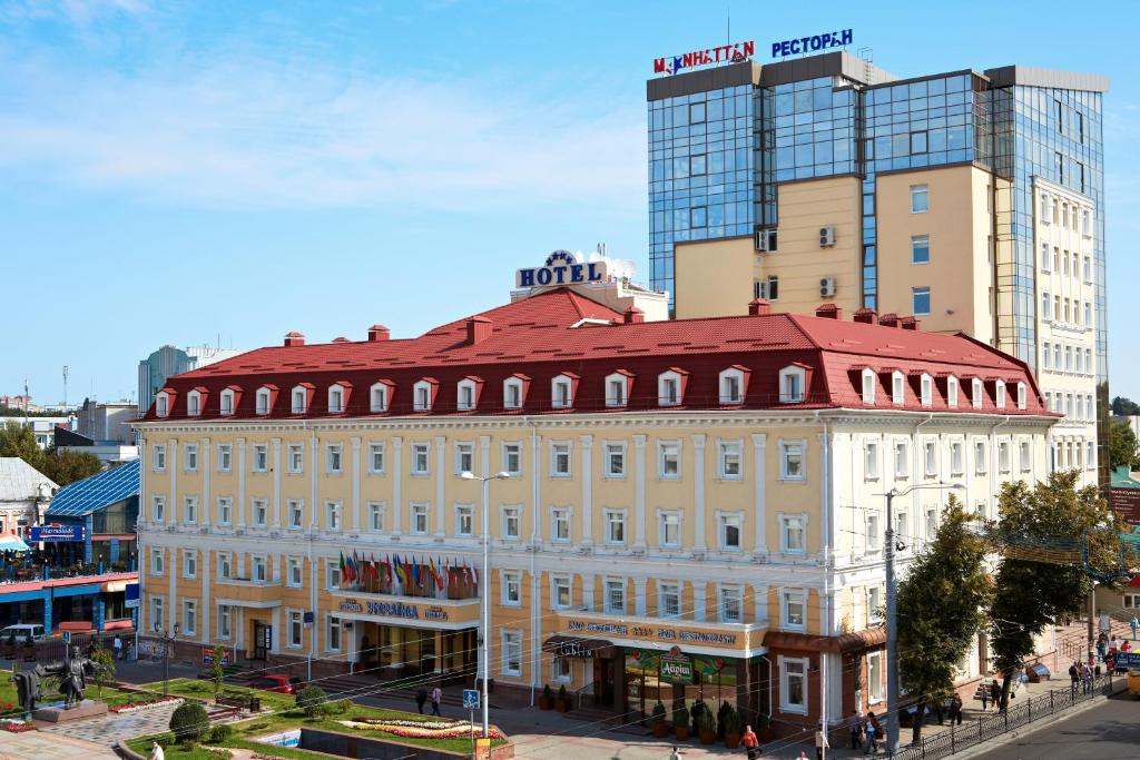a large building on a city street with a tall building at Hotel Ukraine Rivne in Rivne