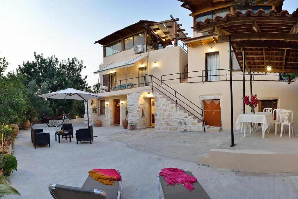 un bâtiment avec des chaises, des tables et un parasol dans l'établissement Raphael Evangellos Villa, à Gavalochori