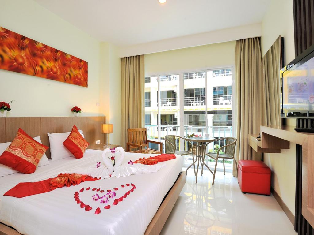 a hotel room with a bed with a heart on it at Pimrada Hotel in Patong Beach