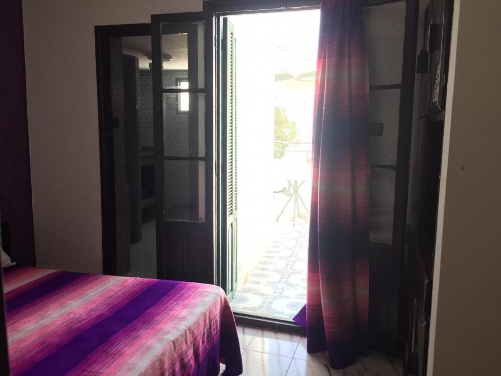 - une chambre avec un lit et une grande fenêtre dans l'établissement HOTEL REGINA, à Tetouan