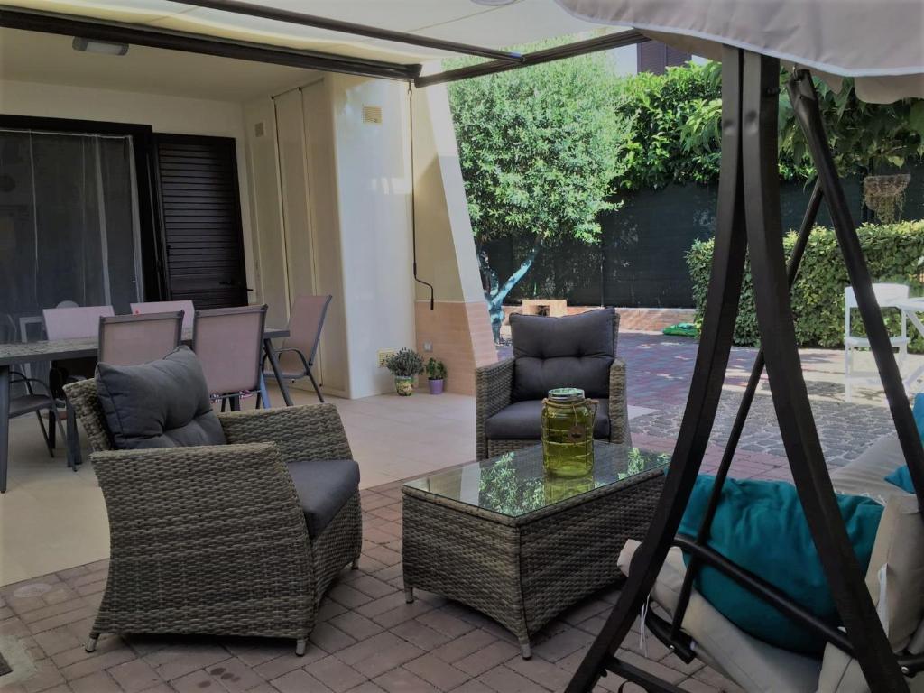 patio con sedie, tavolo e ombrellone di Home Sweet Home a Pulsano