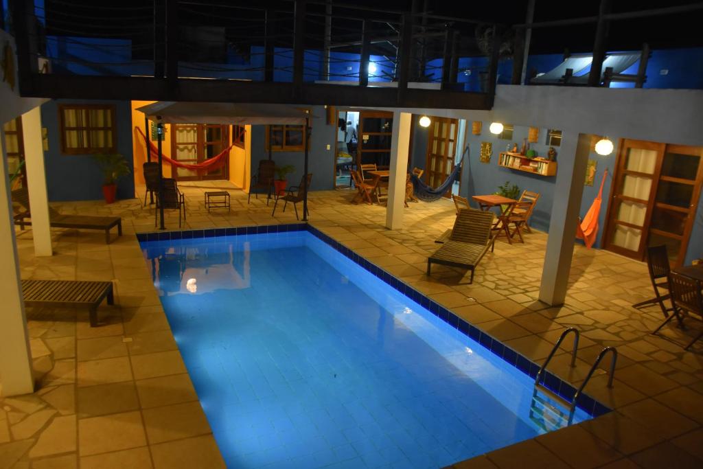 een groot zwembad met stoelen en een tafel bij Pousada Amigos do Vento in Touros