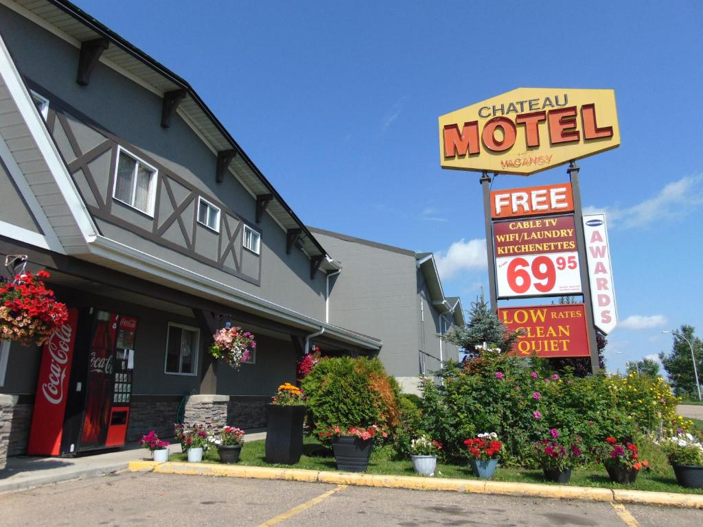 una señal de motel frente a un edificio con flores en Chateau Motel en Edmonton