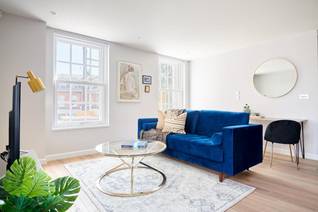 - un salon avec un canapé bleu et une table dans l'établissement Sonder Sloane Square, à Londres