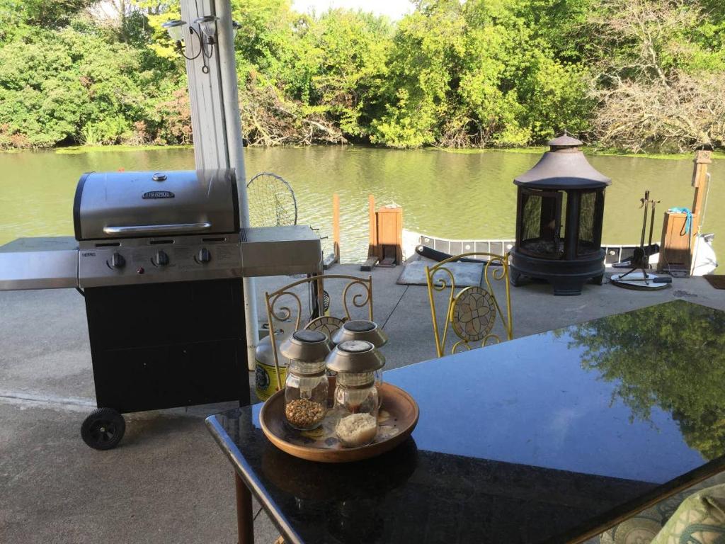 eine Terrasse mit einem Grill und einem Tisch mit Speisen in der Unterkunft Cedar Island Xanadu in Kingsville