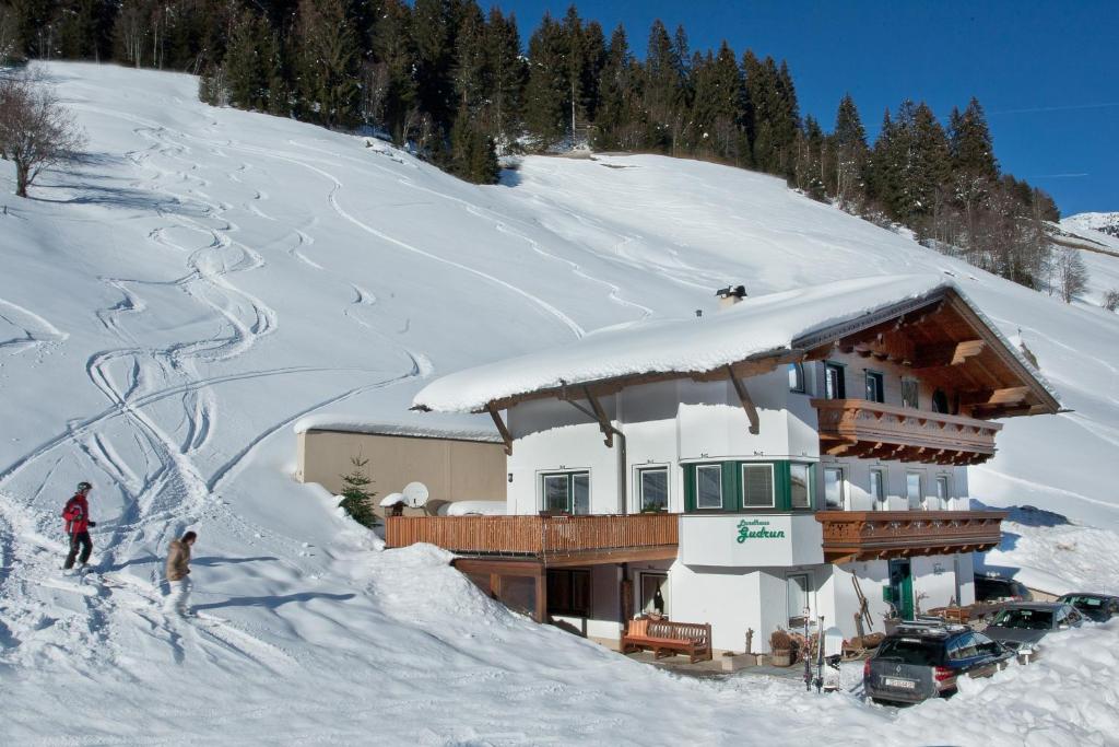 un edificio en una pendiente cubierta de nieve con en Landhaus Gudrun, en Tux