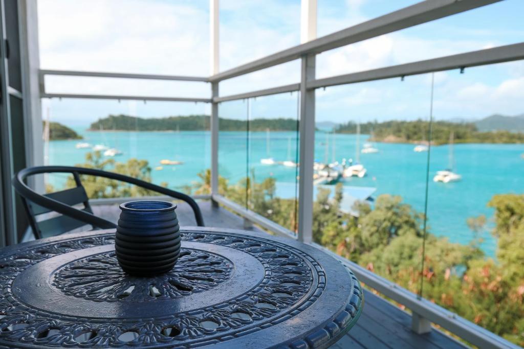 una taza de café en una mesa en un balcón en Yuengee Villas en Shute Harbour