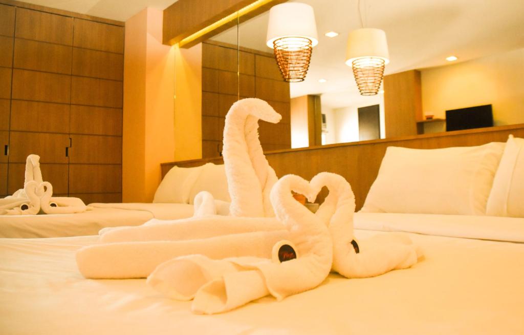 dois cisnes feitos de toalhas numa cama em Tacloban Plaza Hotel em Tacloban