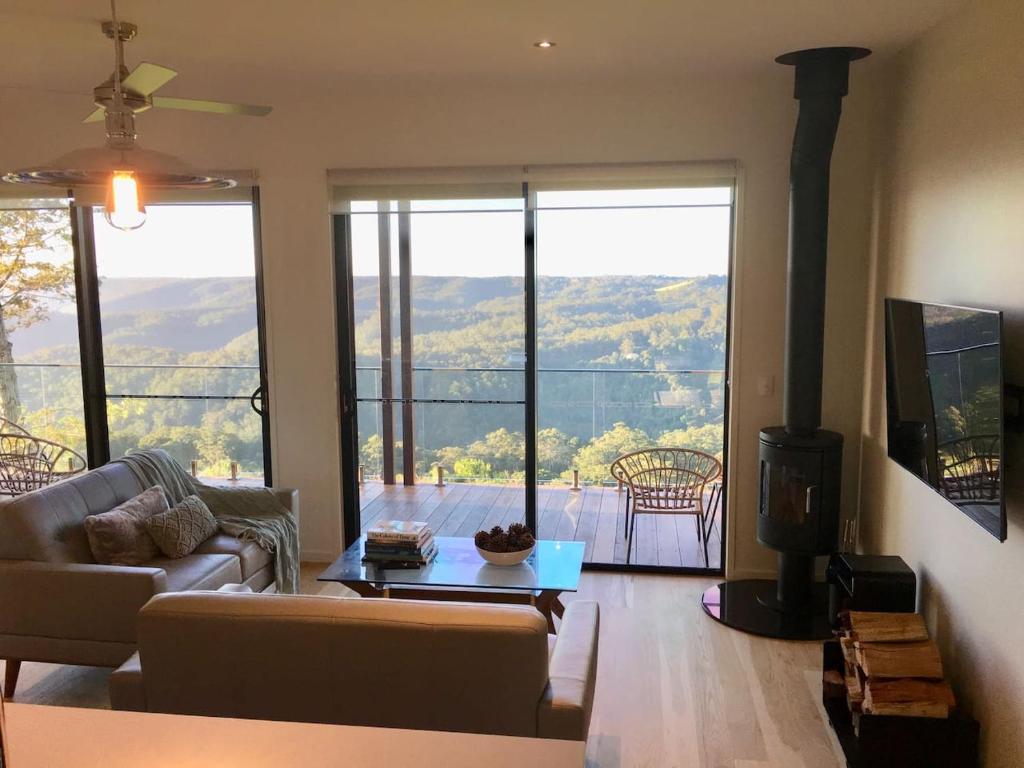 a living room with a couch and a fireplace at Scandinavian Cabin - Maleny - One Bedroom in Maleny