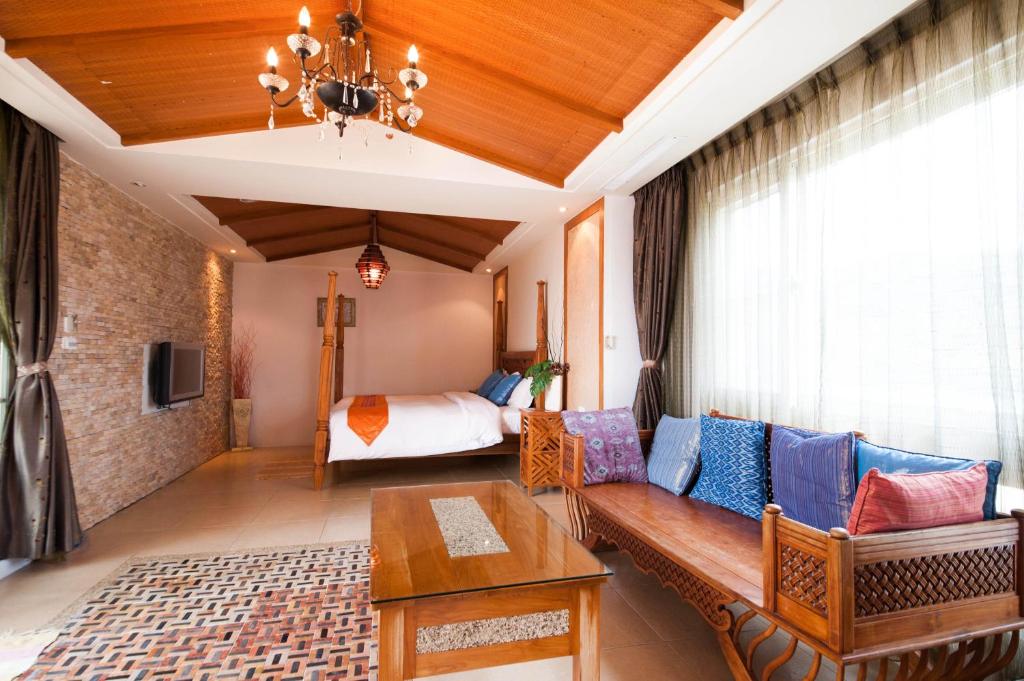 uma sala de estar com um sofá e uma cama em Kenting Shen's Homestay em Eluan