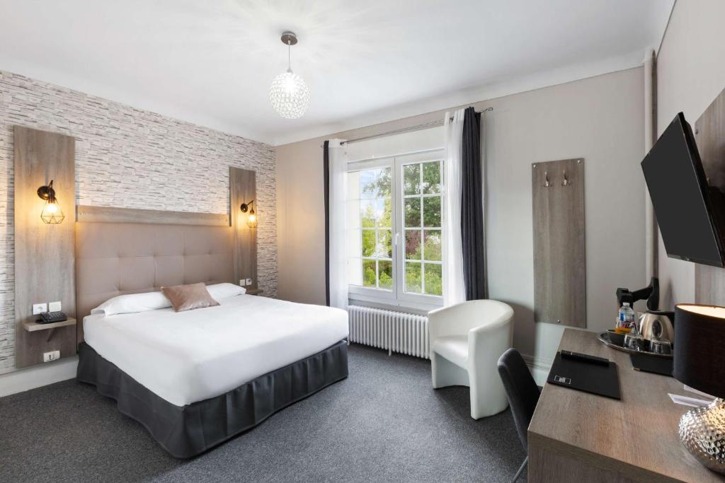 1 dormitorio con cama, escritorio y ventana en Sure Hotel by Best Western Port Jérome - Le Havre, en Notre-Dame-de-Gravenchon