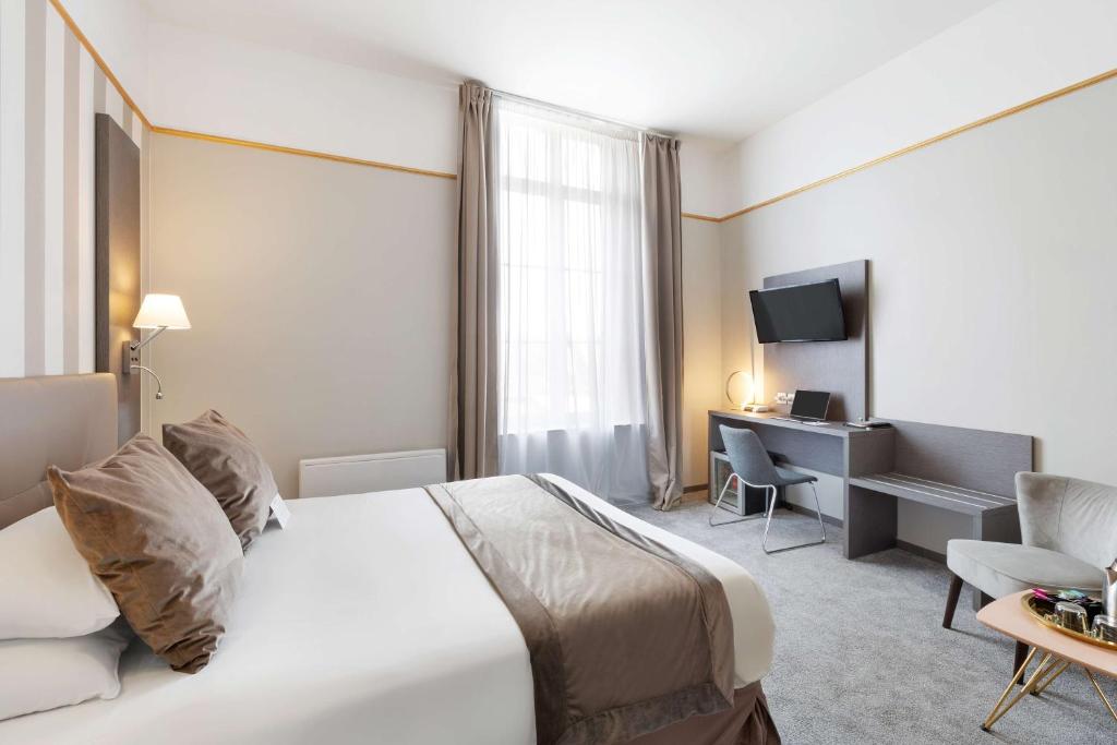 a hotel room with a large bed and a desk at Best Western Hotel Saint Claude in Péronne