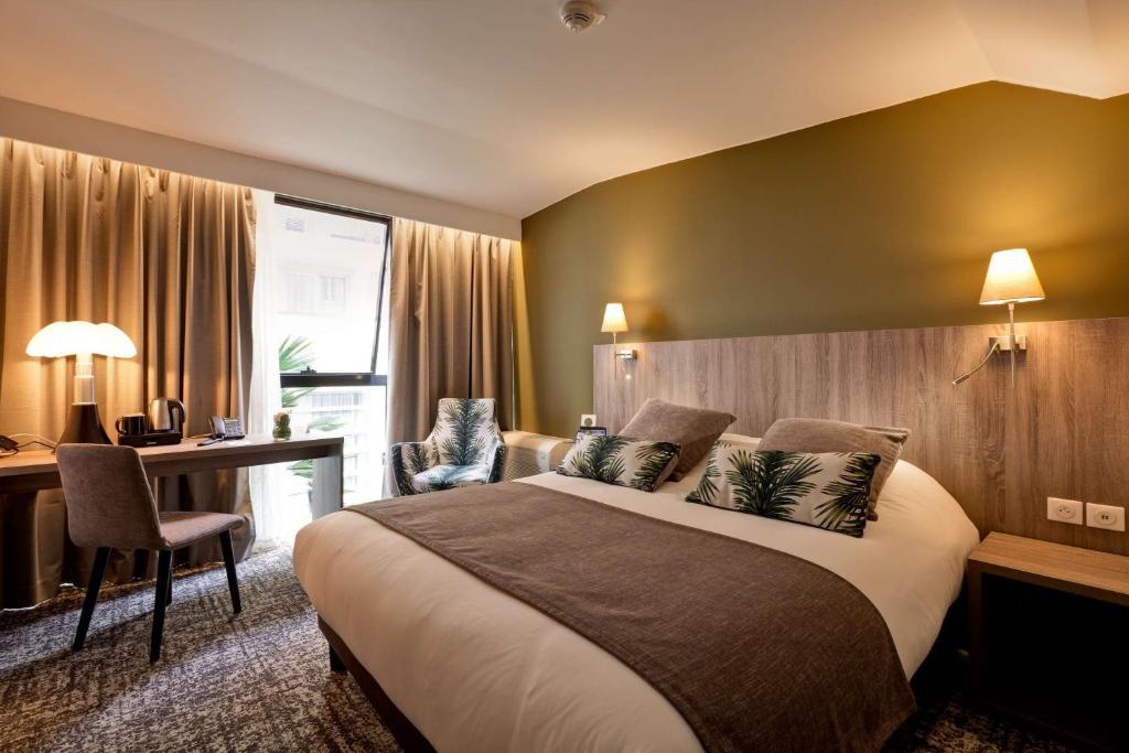 a hotel room with a large bed and a desk at Best Western Crequi Lyon Part Dieu in Lyon