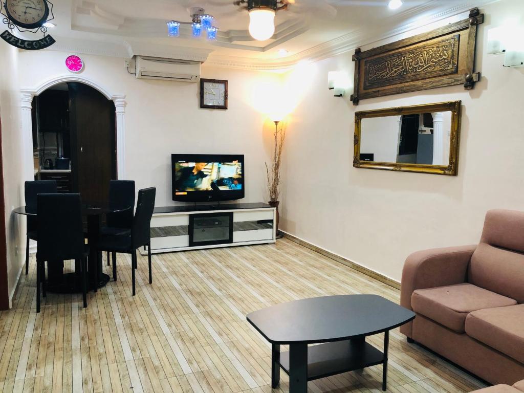 - un salon avec un canapé, une télévision et une table dans l'établissement Atocha Homestay - Sungai Besi@KL, à Kuala Lumpur