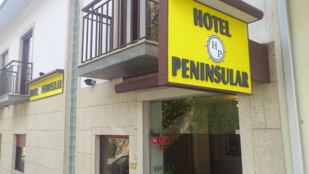 um sinal de pêndulo do hotel na lateral de um edifício em Hotel Peninsular em Caldelas
