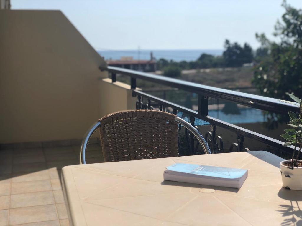 a table with a book on top of a balcony at Blue Sky in Frangokastello