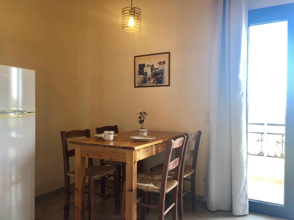 a dining room table with chairs and a refrigerator at Blue Sky in Frangokastello