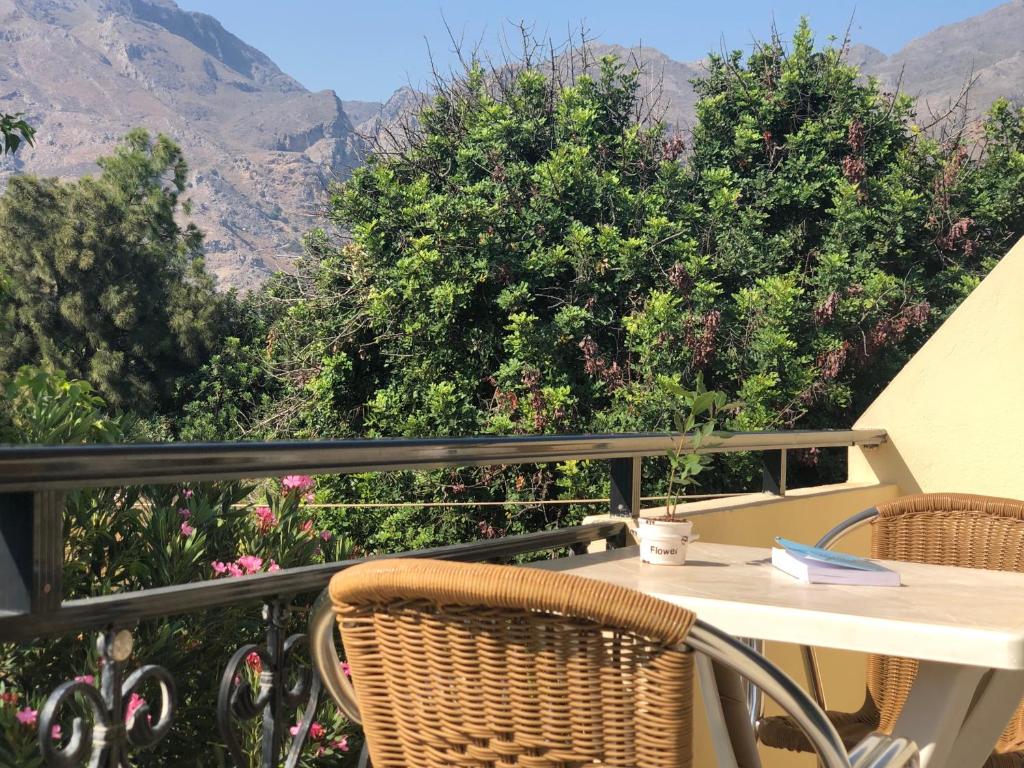 a table and chairs on a balcony with a view of mountains at Blue Sky in Frangokastello