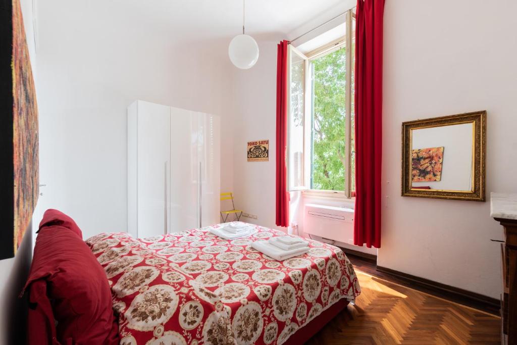 una camera da letto con un letto con tende rosse e una finestra di Appartamento Boboli a Firenze