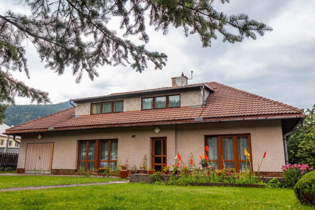 uma casa com um telhado vermelho em Ubytování U Potoka em Lipova Lazne