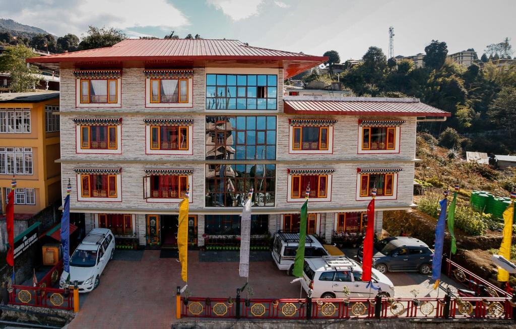 a large building with cars parked in a parking lot at Buddha Retreat in Ravangla