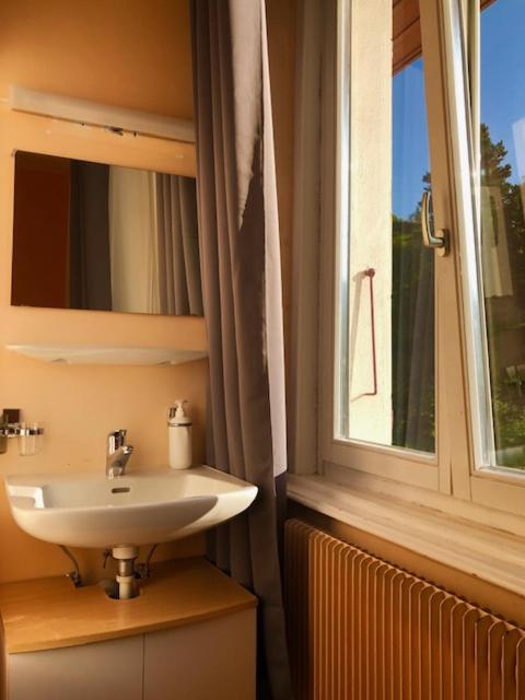 bagno con lavandino e finestra di Auberge Pour Tous a Vallorbe