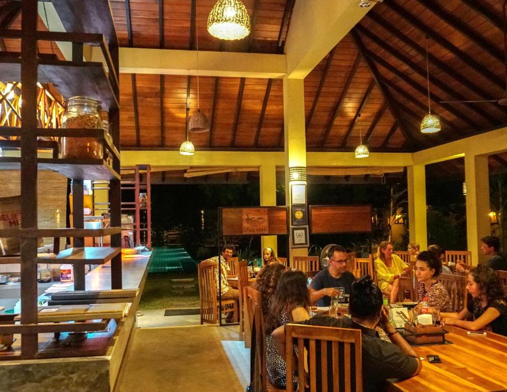 a group of people sitting at a table in a restaurant at The Spice Trail in Arugam Bay