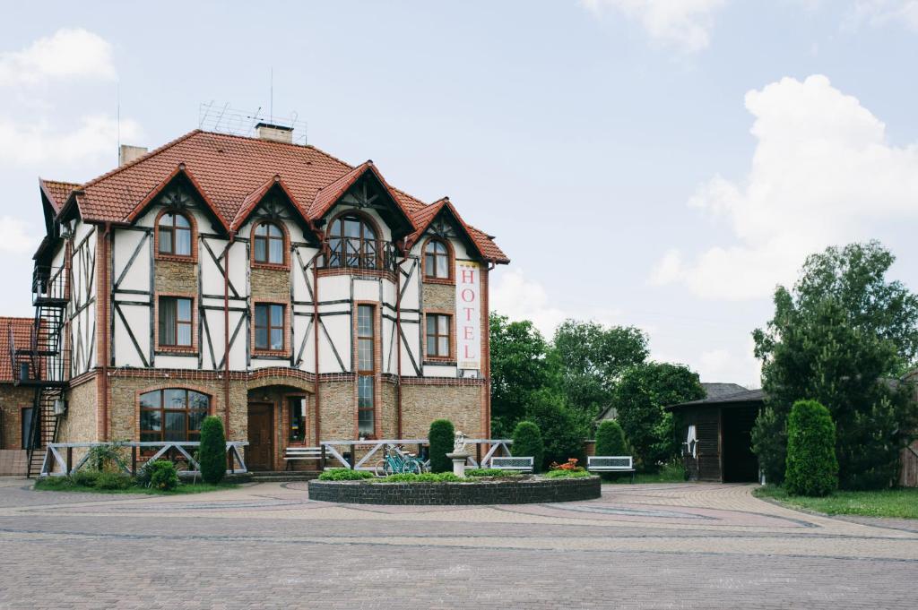 un grand bâtiment en briques avec un toit rouge dans l'établissement Shelter Hotel & Restaurant, à Kolodezhno