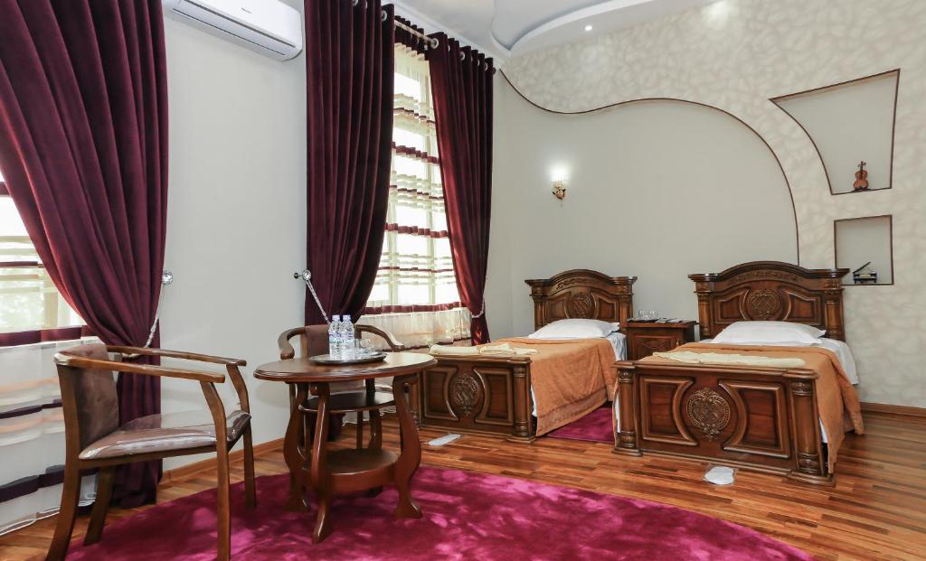 1 dormitorio con 2 camas, mesa y sillas en Luxury Guesthouse, en Samarkand