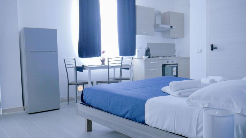 
a room with a bed, a refrigerator, and a television at Naxos Laguna Beach in Giardini Naxos
