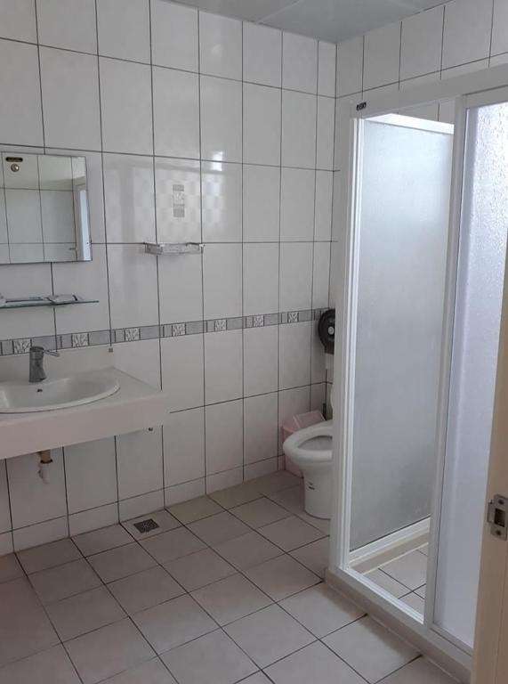 a white bathroom with a toilet and a sink at Star 101 Guest House in Taitung City