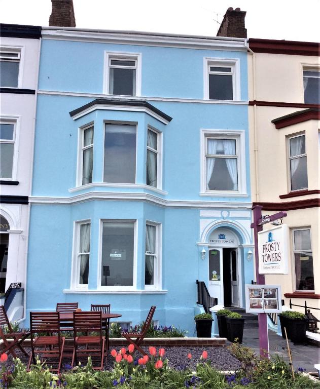 a blue house with benches in front of it at Frosty Towers in Llandudno