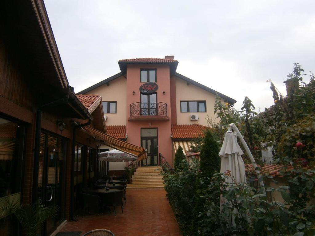 a house with a patio and an umbrella at Evia Hotel in Berkovitsa