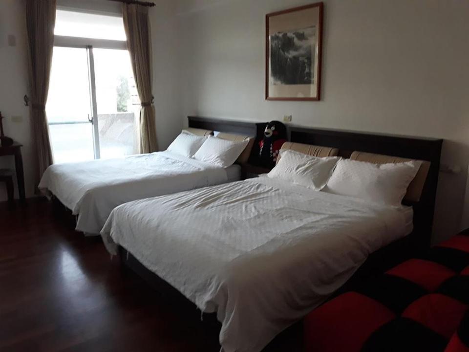 two beds sitting in a bedroom with a window at Star 101 Guest House in Taitung City