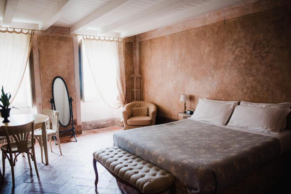 ラーリオにあるRegina Teodolinda Suitesのベッドルーム1室(ベッド1台、テーブル、椅子付)
